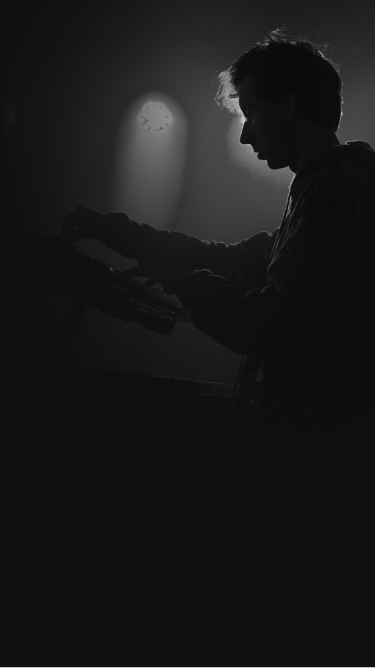 Musician playing a keyboard in a dimly lit stage